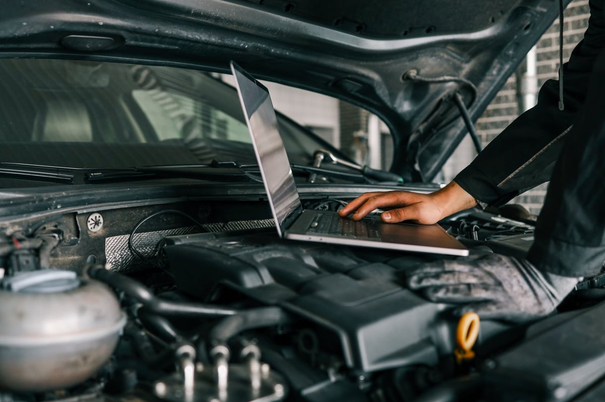 Mechanic using laptop for car diagnostics