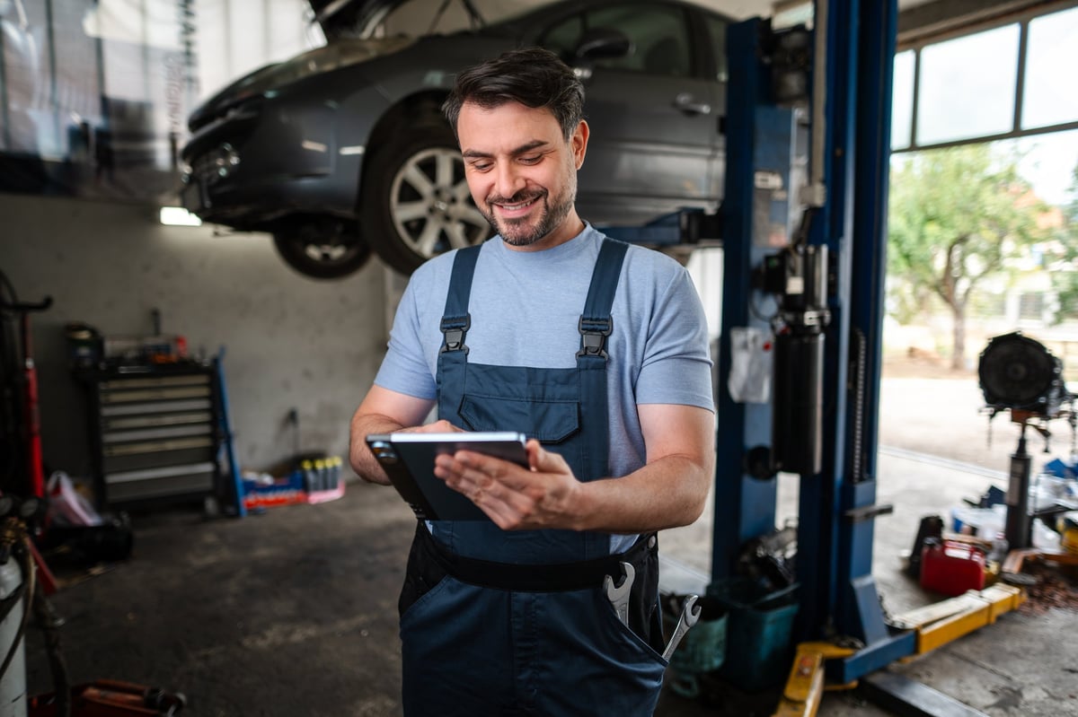 Mechanic using digital tablet at auto repair shop
